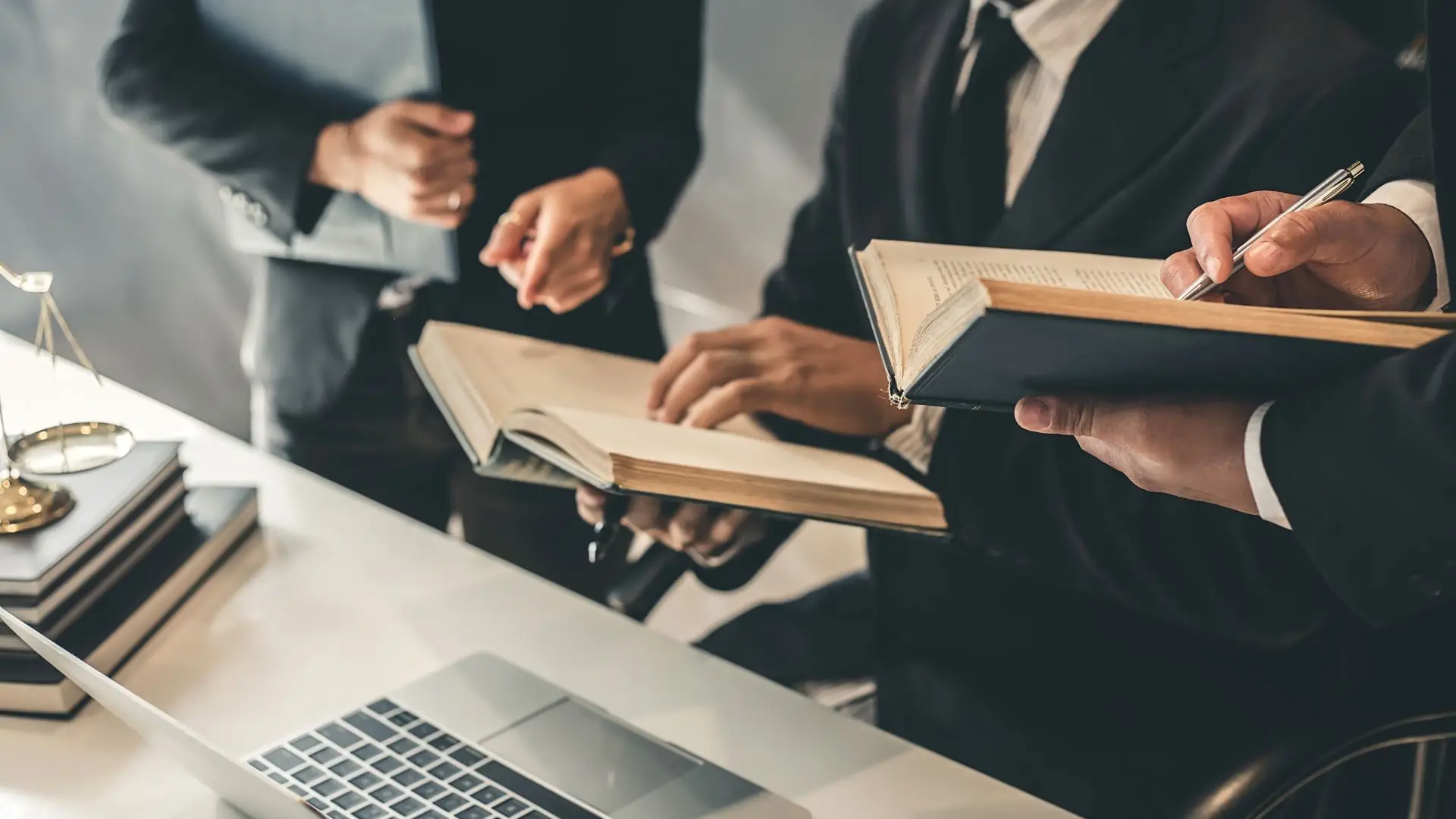 Abogados sosteniendo libros y hablando sobre un caso