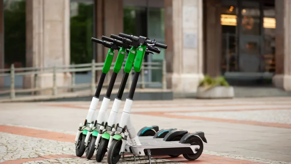 A row of electric scooters parked outside a building.