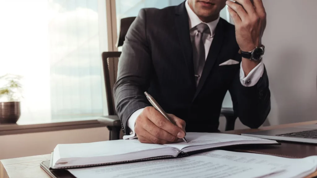 A lawyer on the phone while taking notes.