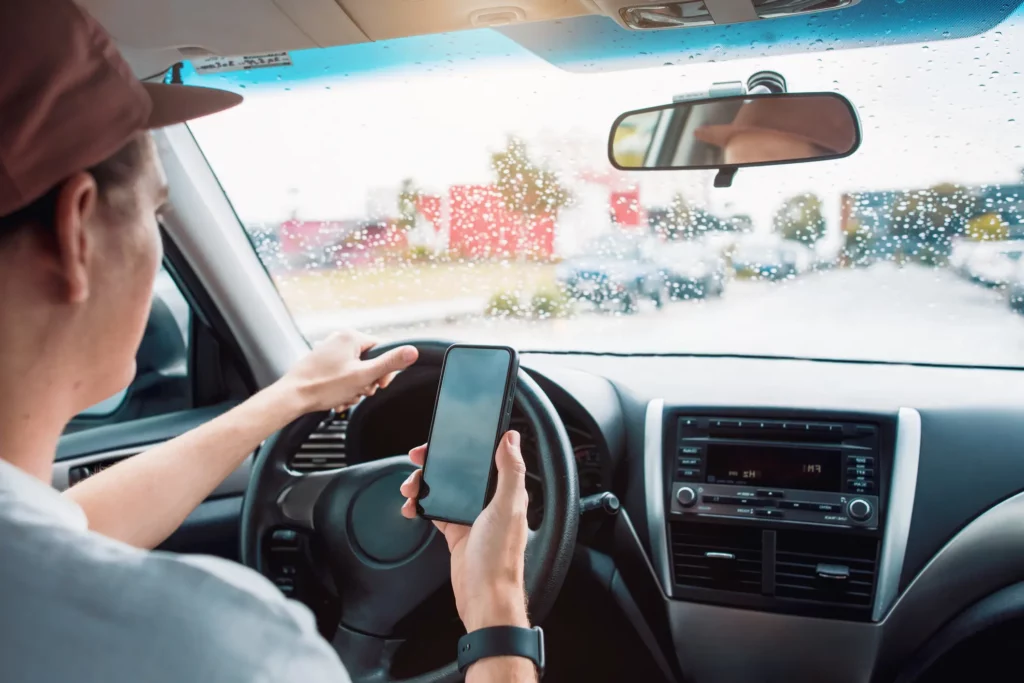 A driver using their phone while behind the wheel.