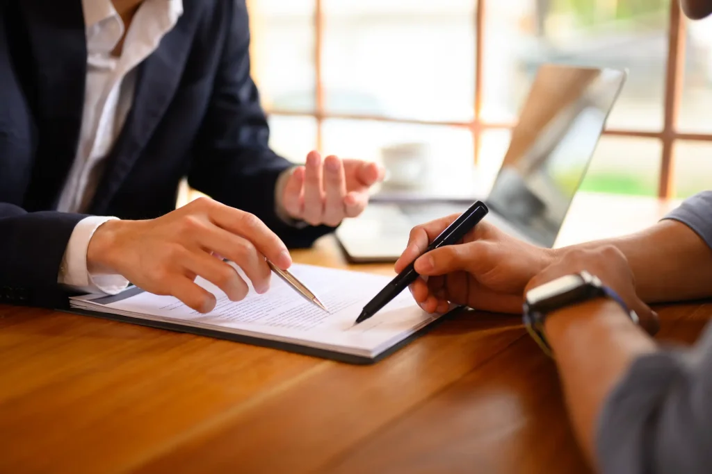 A person signing a document with an attorney.