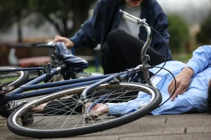 A person coming to help someone who has been in a bike accident.