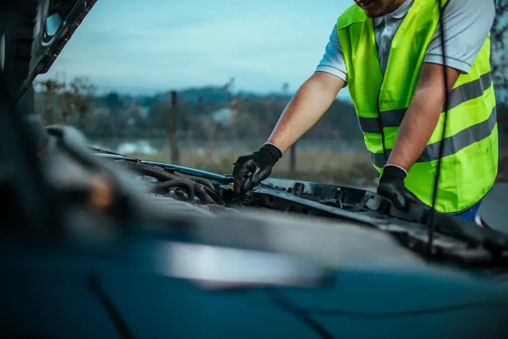 A mechanic working on a broken car.