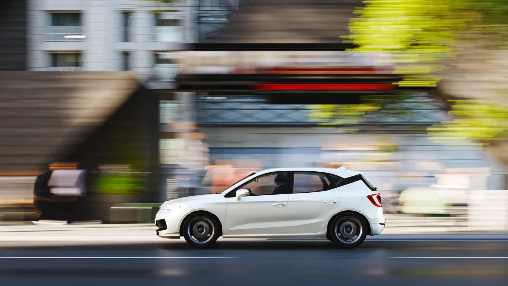 A speeding car racing through the street.