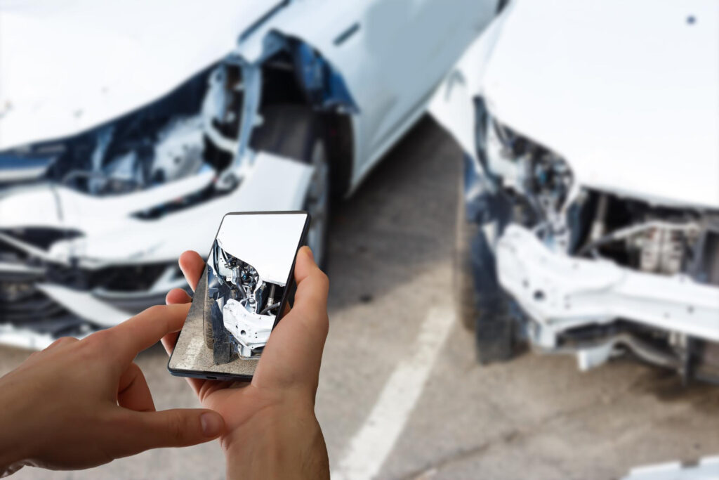 Man photographing his vehicle with damages for accident insurance