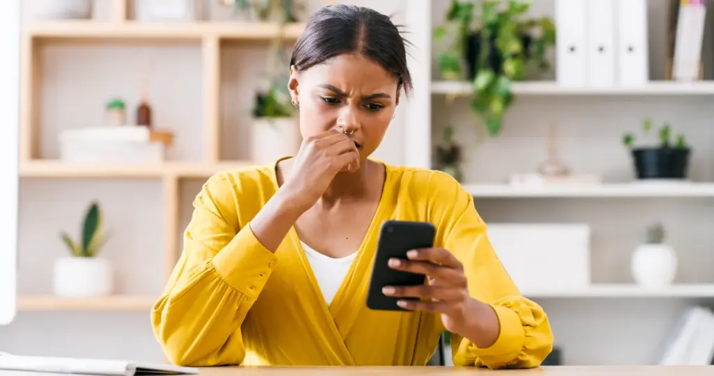A concerned woman looking at her phone.