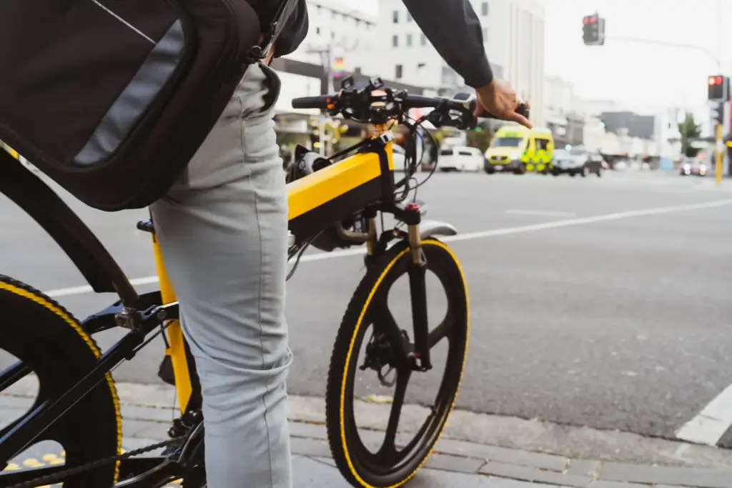 A person riding a yellow electric bike throughout a city.