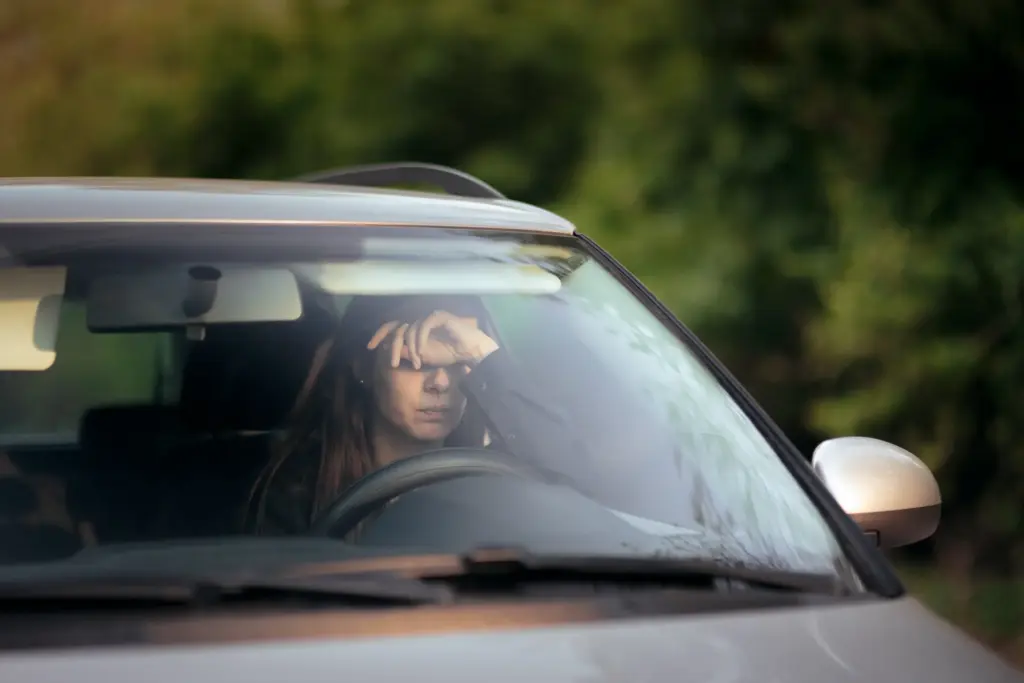 A tired woman sitting in the car. 