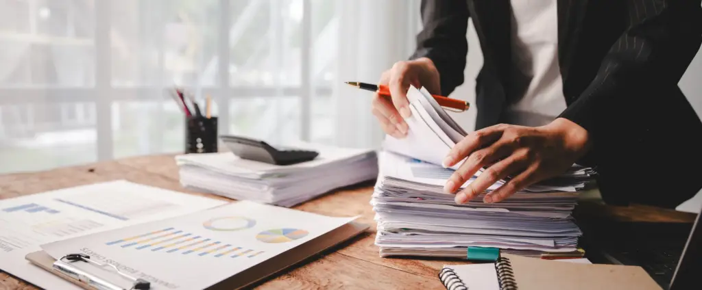 An attorney trying to find something in a huge stack of papers.