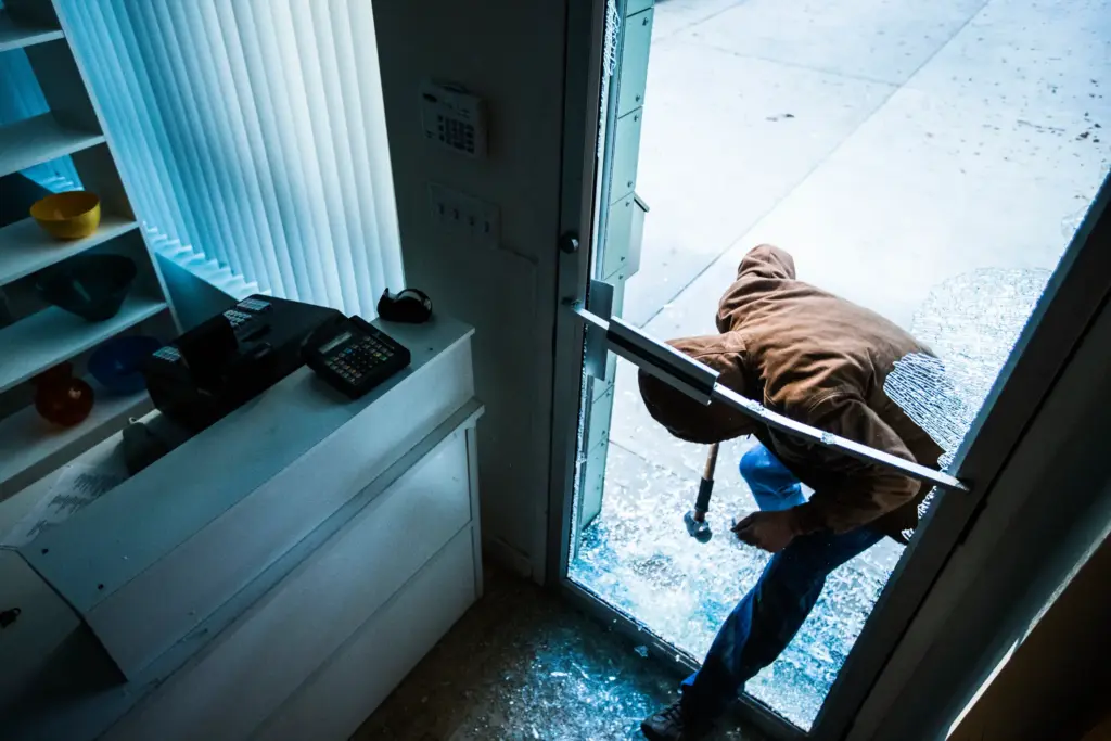 A person breaking and entering a building.