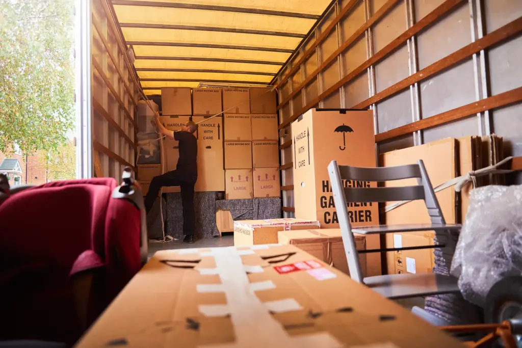 A man packing a truck with moving boxes.