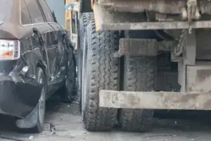 A semi truck hitting the side of a car. 