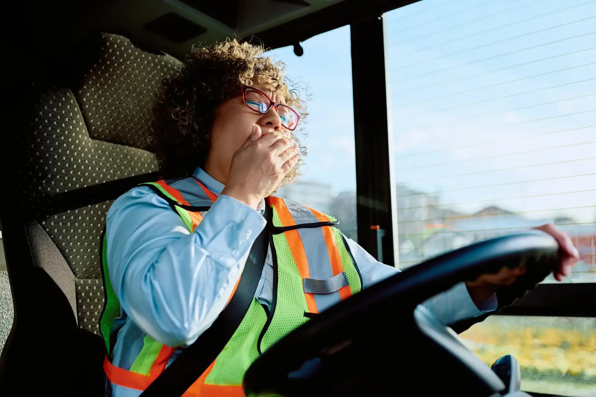 A yawning bus driver while they are still on their shift.