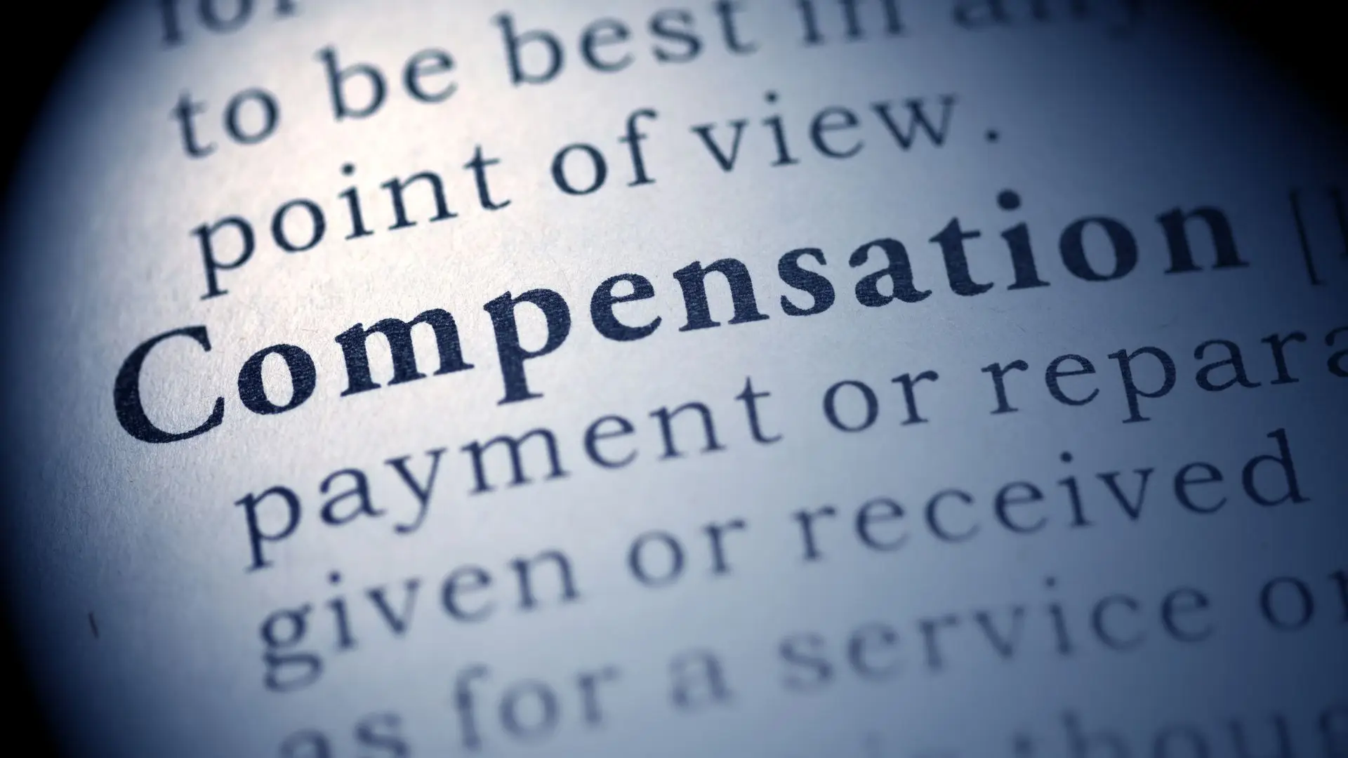 A dictionary with the word "compensation" bolded and focused on.