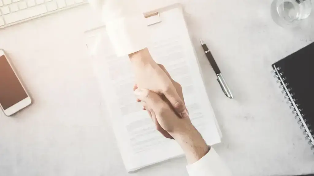 A handshake occurring over a document.