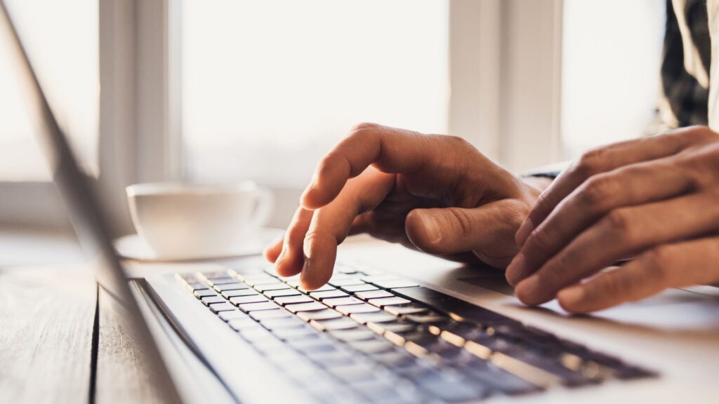 A person typing on the computer.