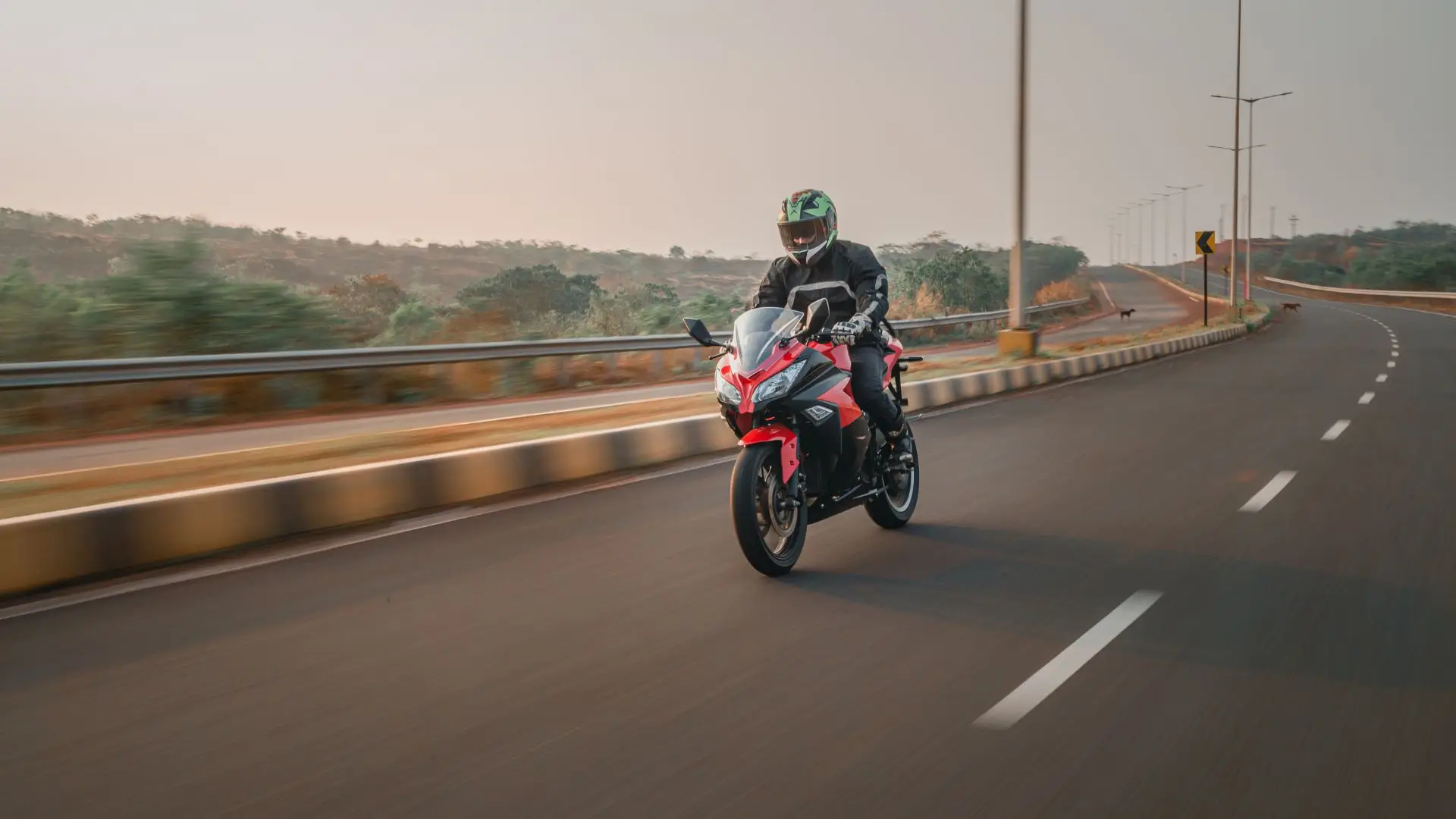 A motorcycle rider driving on a empty freeway.