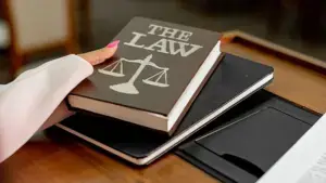 A woman grabbing a law book from a table.
