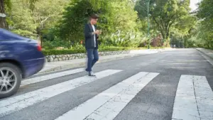 A person jaywalking after a car dashed past them. 