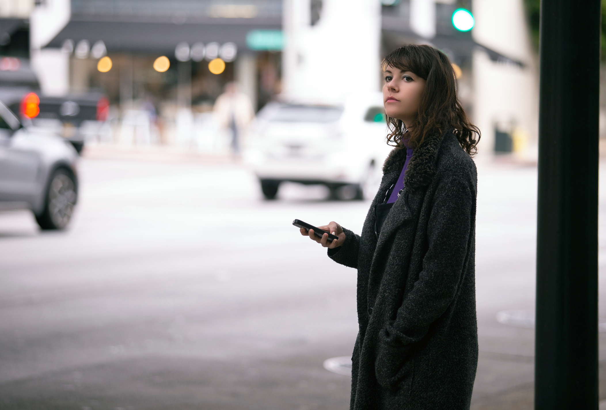 A women waiting for her rideshare car to arrive.