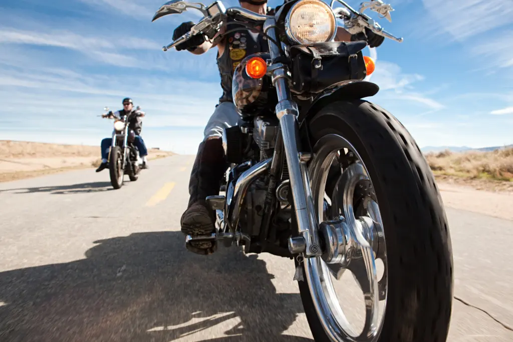 Two motorcyclists riding through a desert.