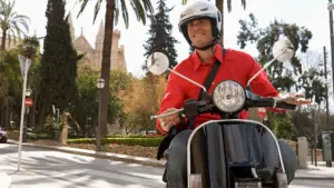A man riding a moped on a street.