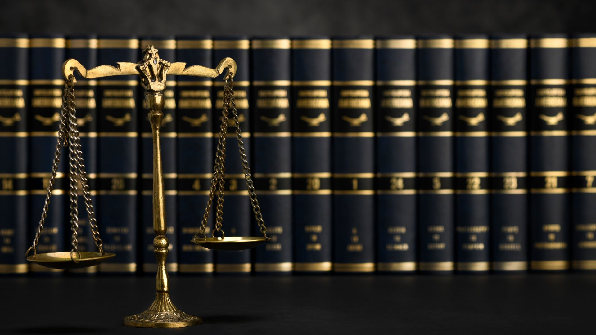 A row of books with the scale of justice in front. 