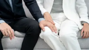 A man putting his hand on a woman's leg.