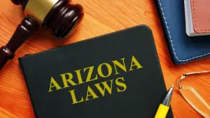 A book titled "Arizona Laws" with a gavel and books next to it.
