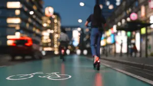 A woman riding an electric scooter in a bike lane.