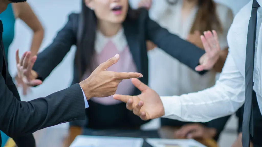 Two men arguing while a woman tries to calm them down.