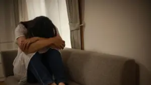 A sad woman crying on the couch.