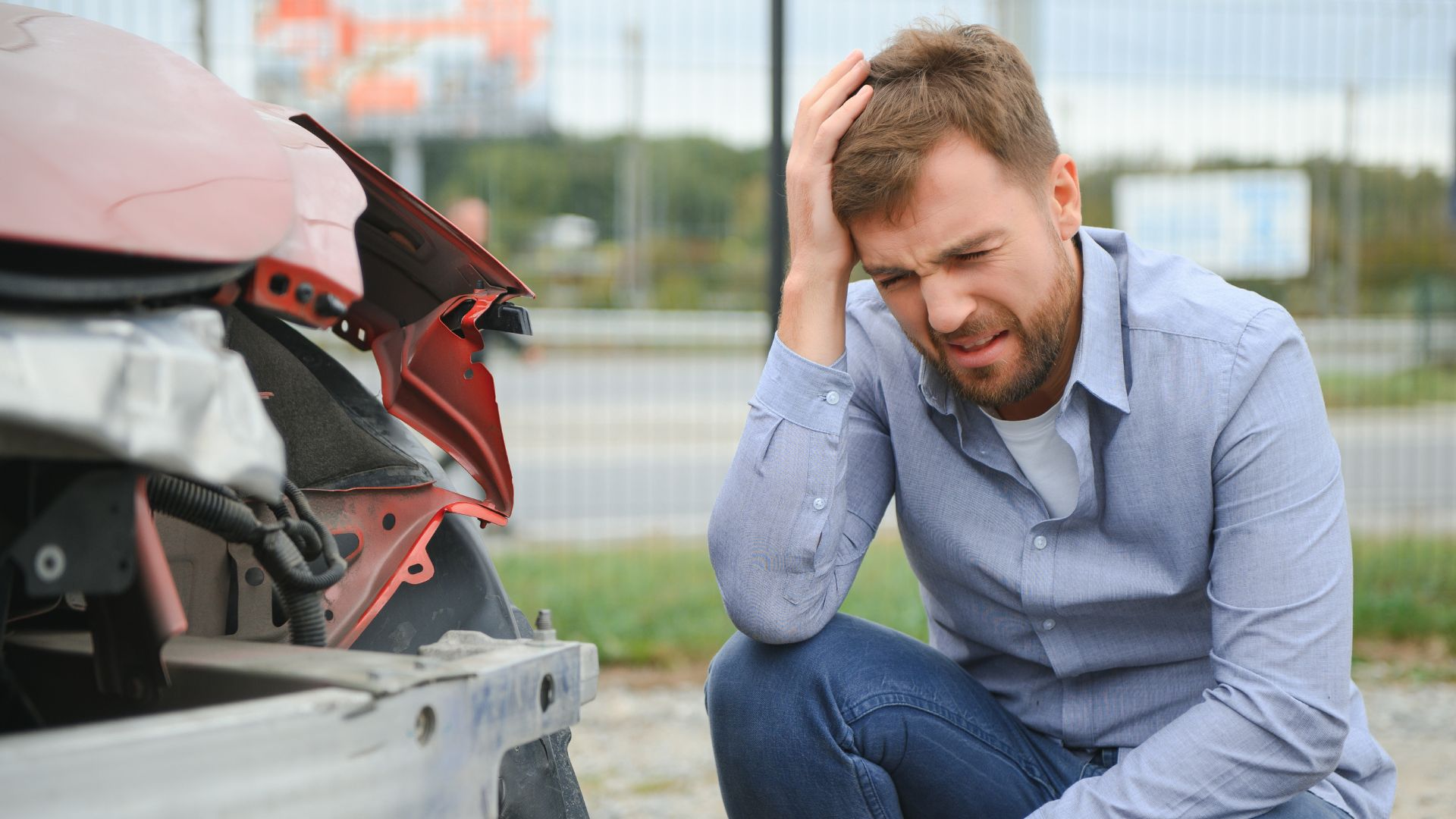 A man holding his head after a car accident.