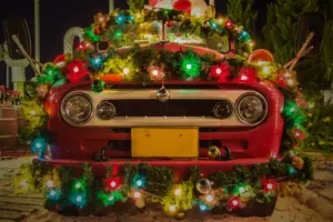 A close up of a front bumper of a car that is decorated with Christmas decorations. 