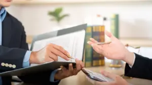 An attorney holding a folder and talking to a client. 