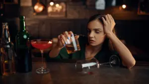 A drunk woman falling asleep at the bar.