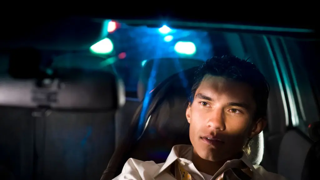 A drunk driver getting pulled over by a police officer.