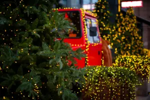 A truck with Christmas lights and tree bristles. 
