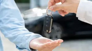 A person handing their car keys to another person.