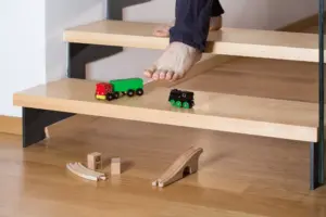 A person about to step on toys on the stairs.