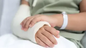 A person with a broken arm resting at a hospital.