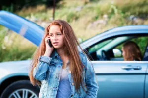 A woman on the phone after an accident has happened.