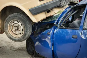 A severe car accident where one car is on top of another car.