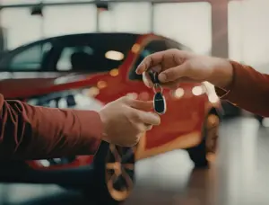 A person buying a car at a dealership.