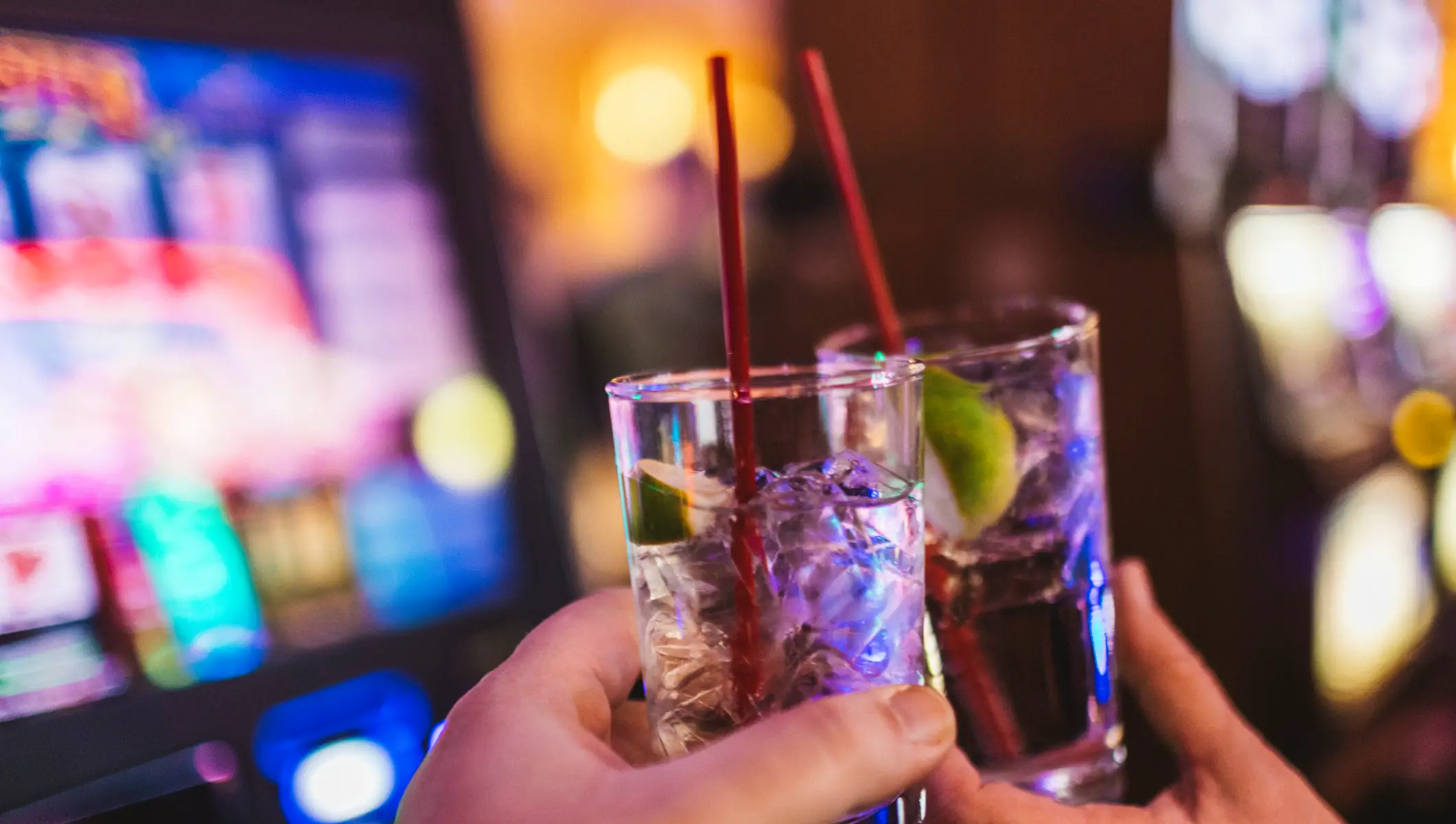 Two people clanking their drinks at a Las Vegas casino.