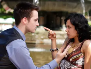 A couple pointing the finger at each other.