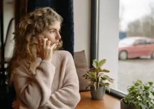 A woman on the phone while looking outside.