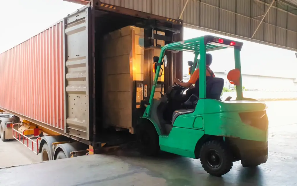 A forklift loading cargo in a truck.