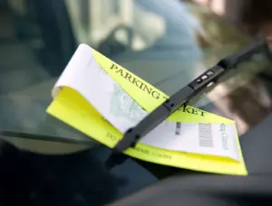 A parking ticket on a car's windshield.