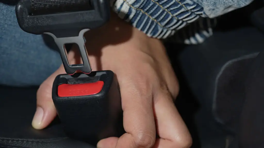 A closeup of a person clipping on a seatbelt.